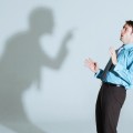 Businessman being scolded by his shadow